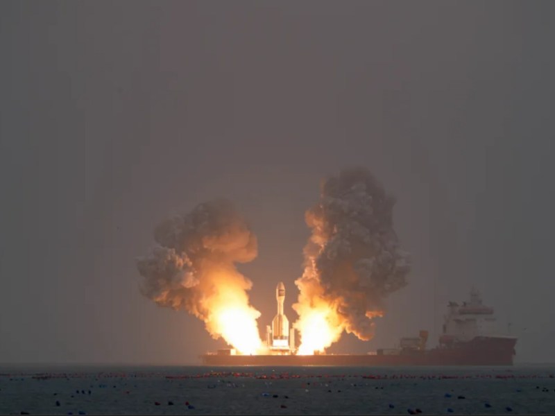 Gravity-1 solid rocket lifting off from a barge in the Yellow Sea during its second launch on October 11 2025, with bright exhaust flames and thick plumes of smoke rising into a hazy sky,