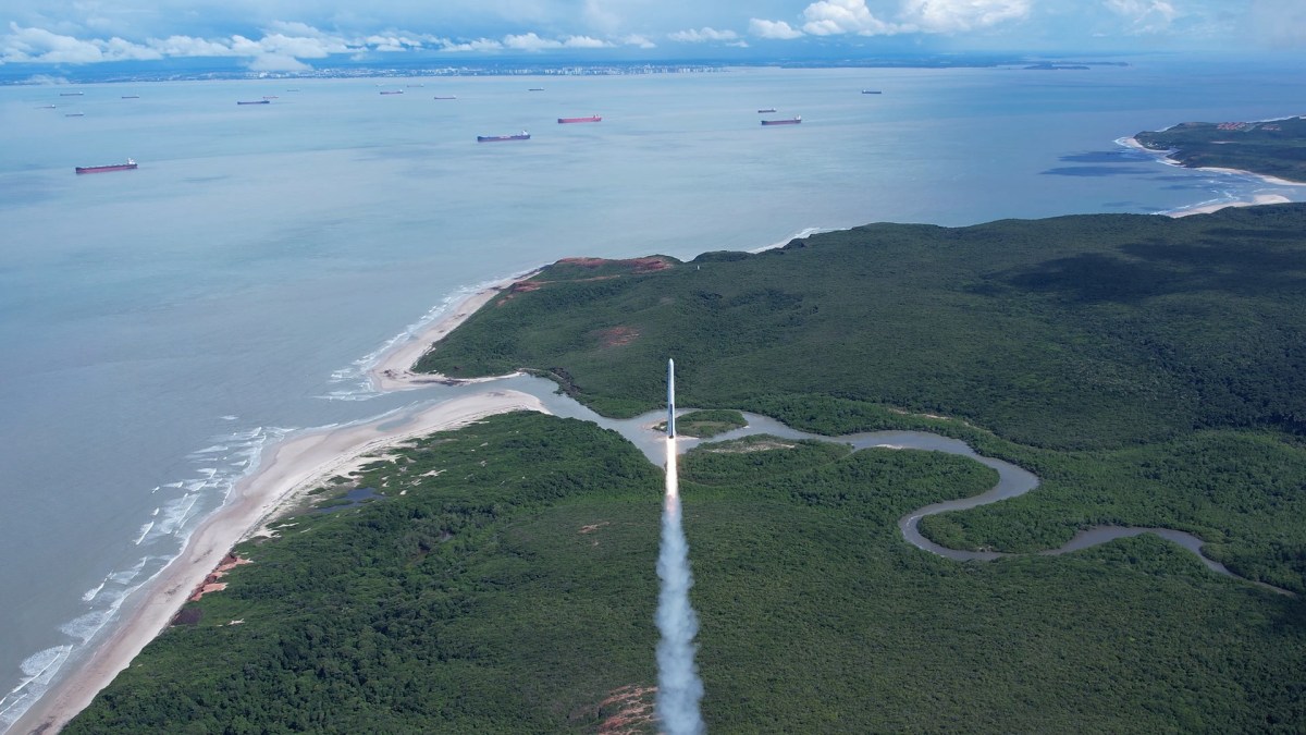 A white rocket lifts off from a seaside launch site in Brazil.