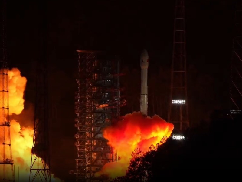 China's Long March 3B rocket launches the Tianwen-2 asteroid and comet mission from Xichang Satellite Launch Center at night, with bright orange flames and smoke illuminating the pad.